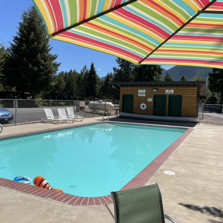 Image of teal blue pool and pool house at Nugget RV Park
