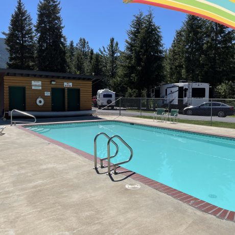 Image of teal blue pool and pool house at Nugget RV Park