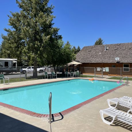 Image of teal blue pool and pool house at Nugget RV Park