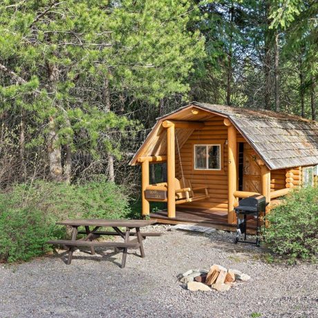 Image of cabin exterior with porch swing and grill at Nugget RV Park